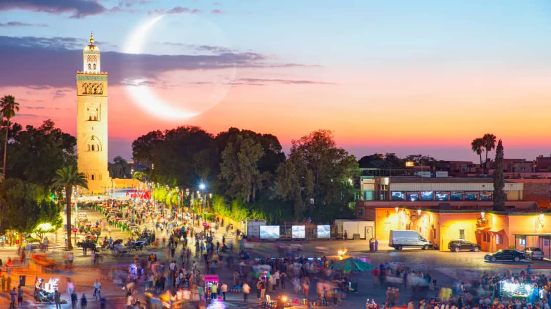 Jemaa el-Fna square in Marrakech at dusk with food stalls and lanterns glowing