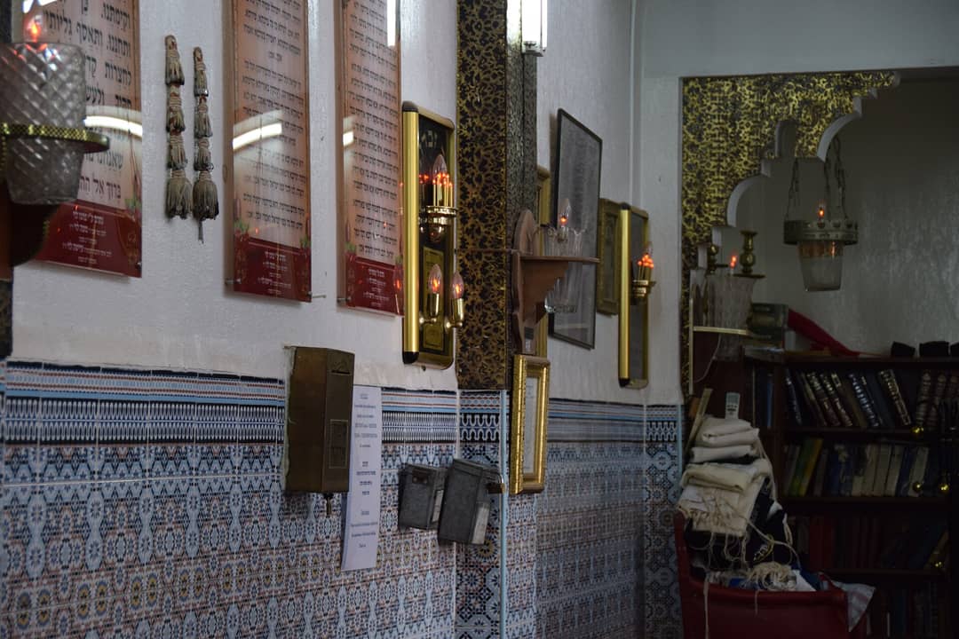 Courtyard of the Lazama (Slat al-Azama) synagogue in the Marrakech mellah, with blue-and-white tilework and a citrus tree