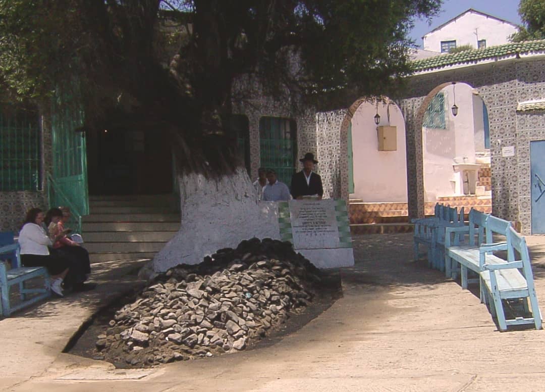 Candles on the stone cairn of Rabbi Amram Ben Diwan’s grave under an olive tree at Asjen