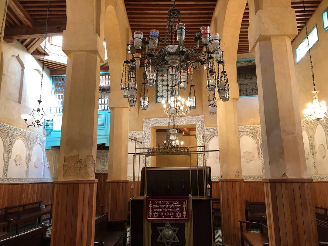 Arcaded prayer hall of the restored Slat al-Fassiyin Synagogue in the Fes mellah, with zellij and carved stucco
