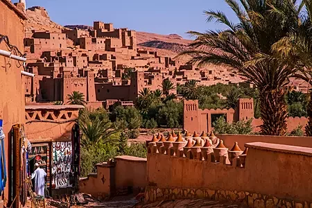 Traditional red-earth Berber Kasbah (fortified village) nestled in the foothills of the Atlas Mountains, showcasing Berber architecture
