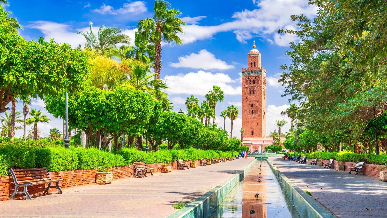 La Koutoubia Mosque in Marrakech with its iconic minaret rising above palm trees and gardens, a highlight of our Morocco city tours